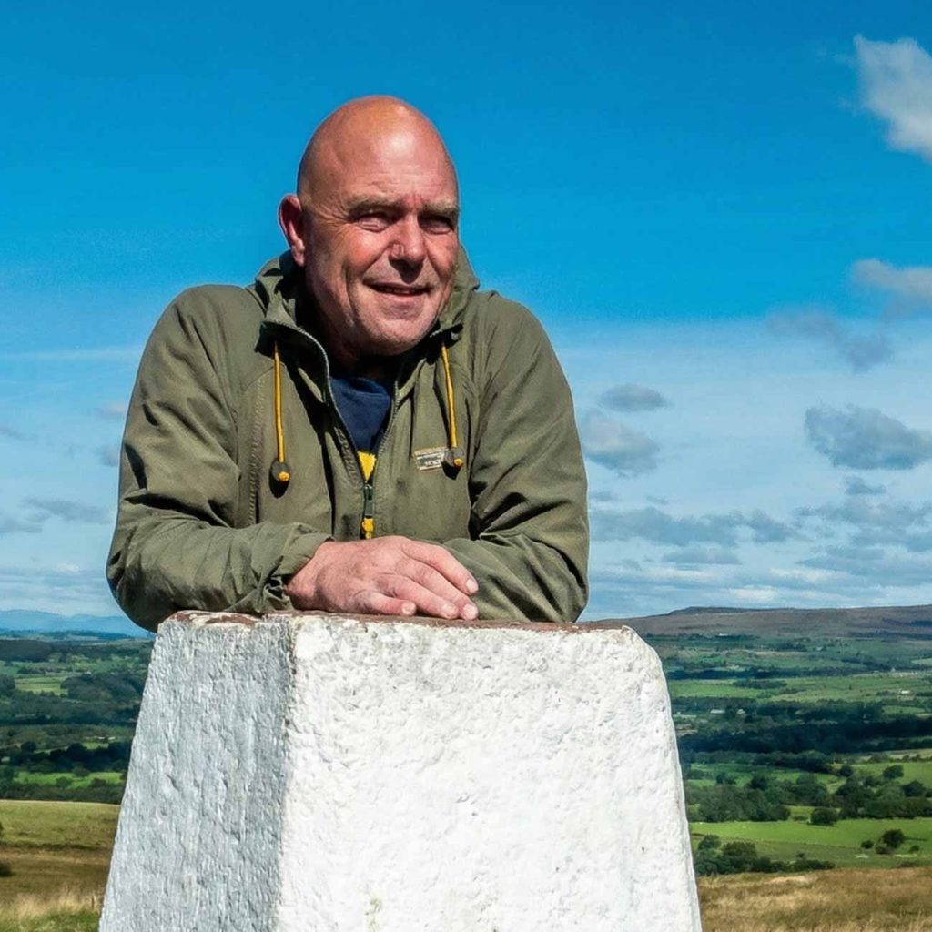 Paul Steele, the BaldHiker at a Trig Point on a hike
