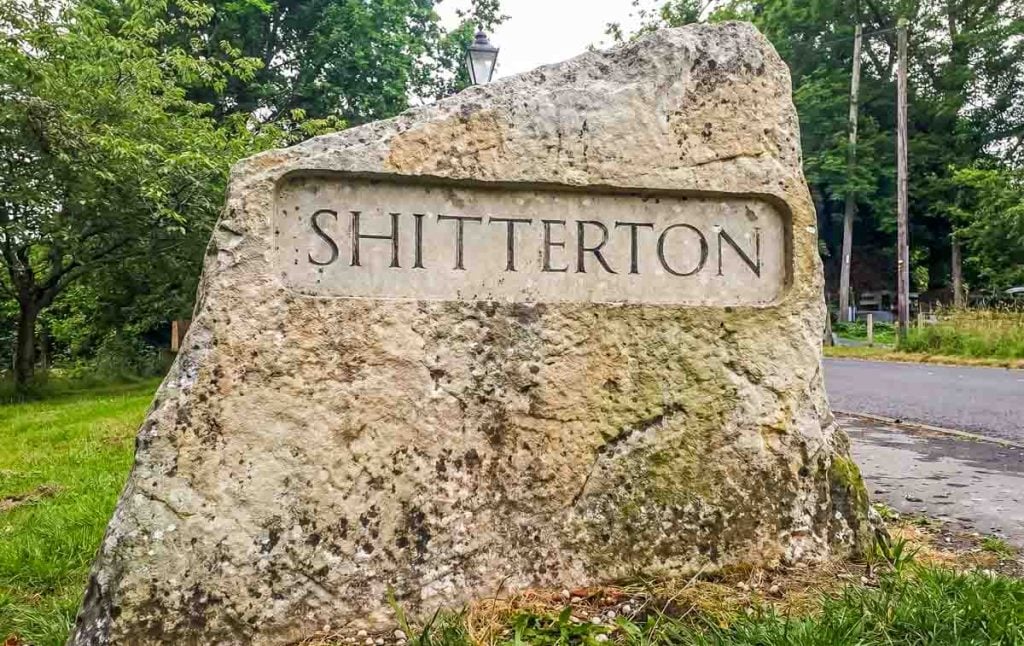 stone sign on entry to Shitterton