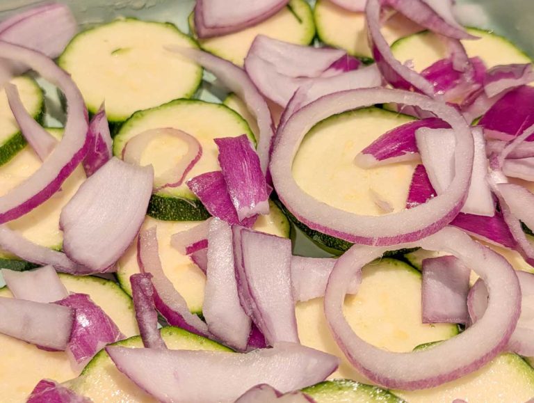layering the gratin with courgette and onion slices