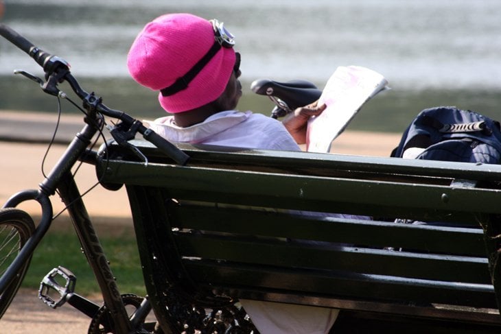 cyclist resting on a park bench