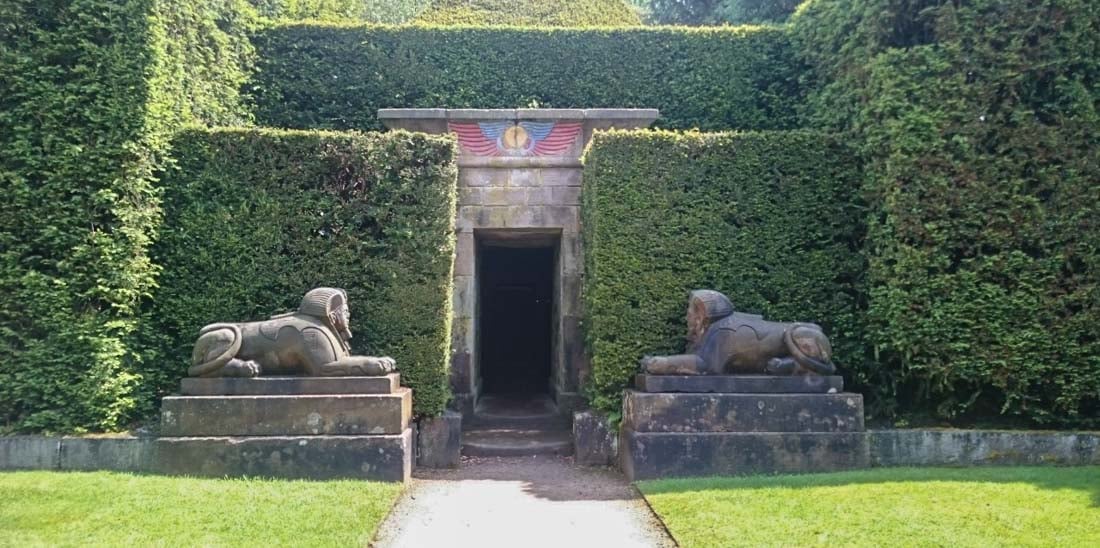 a stone entrance to egypt garden with 2 sphinx