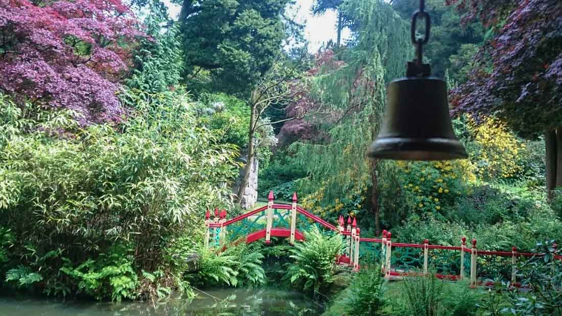 a bell over a small bridge in the chinese garden